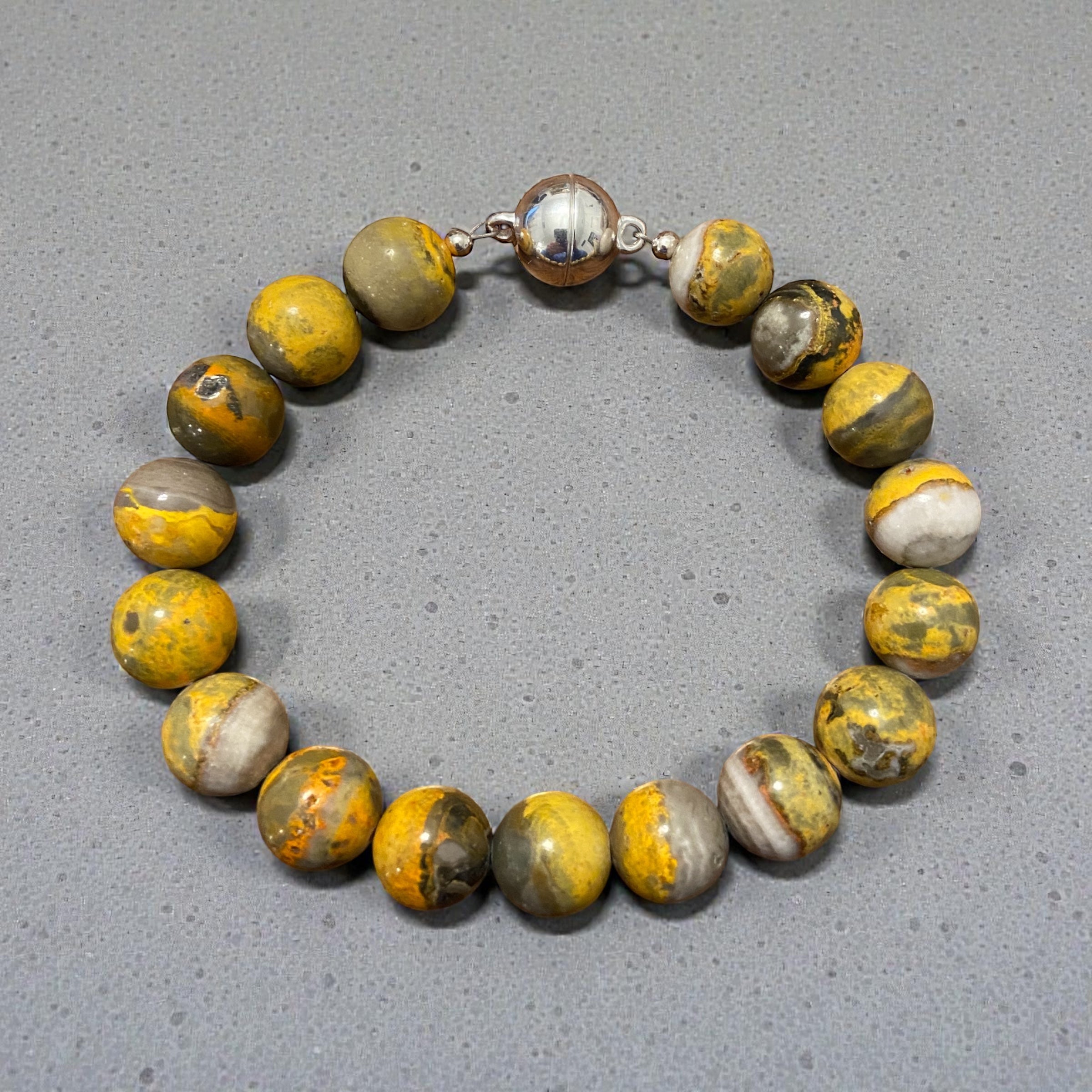 Bracelet with yellow and gray beads on a gray background