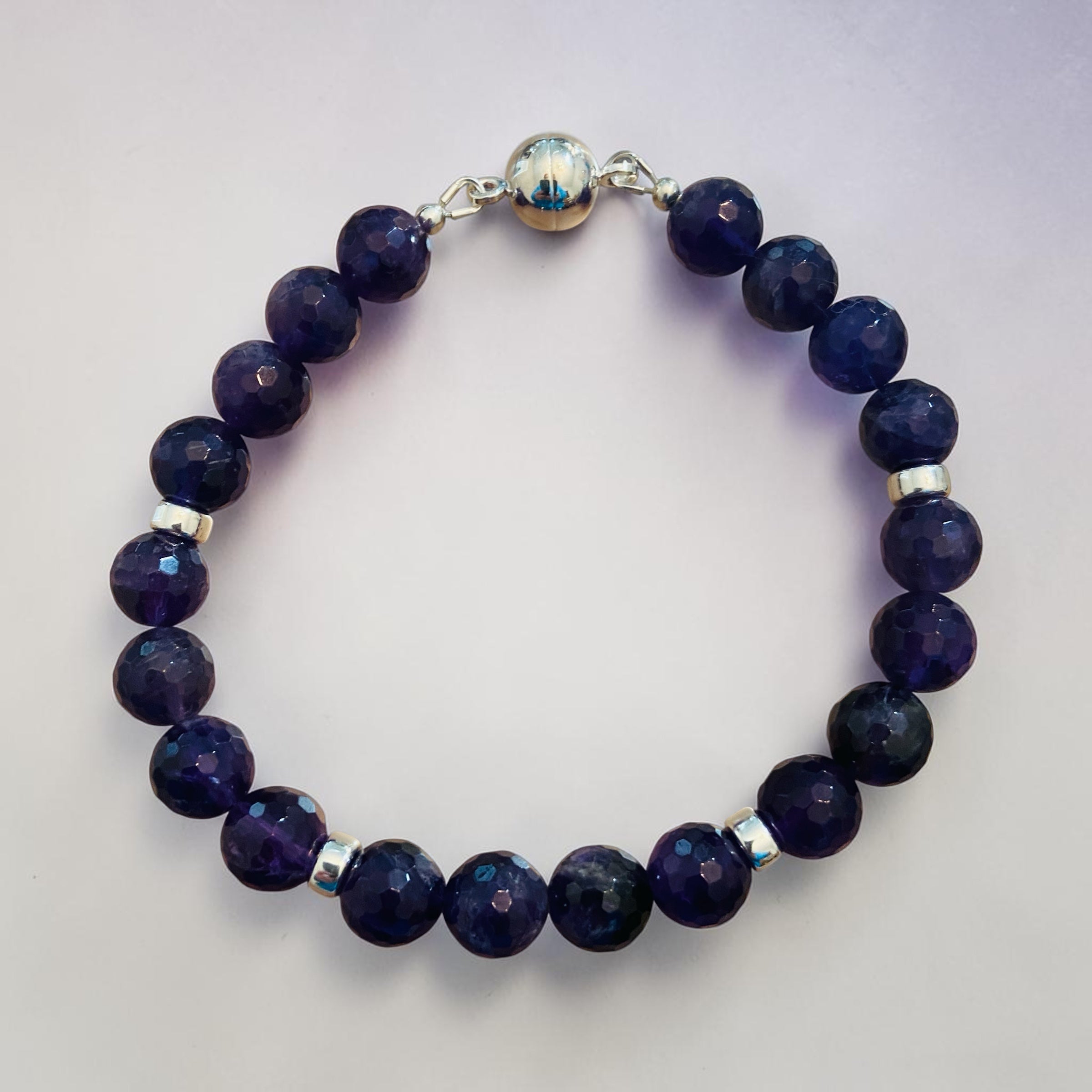 Men's Amethyst Bracelet with dark blue beads and silver accents on a light gray background
