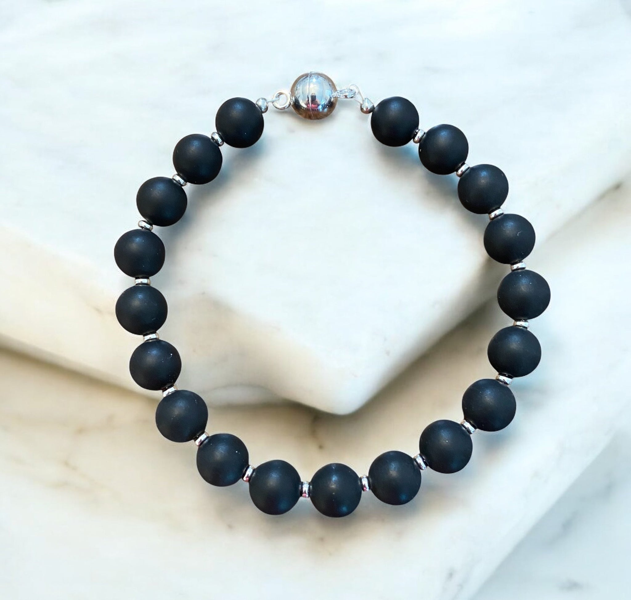 Black onyx bracelet with silver clasp displayed