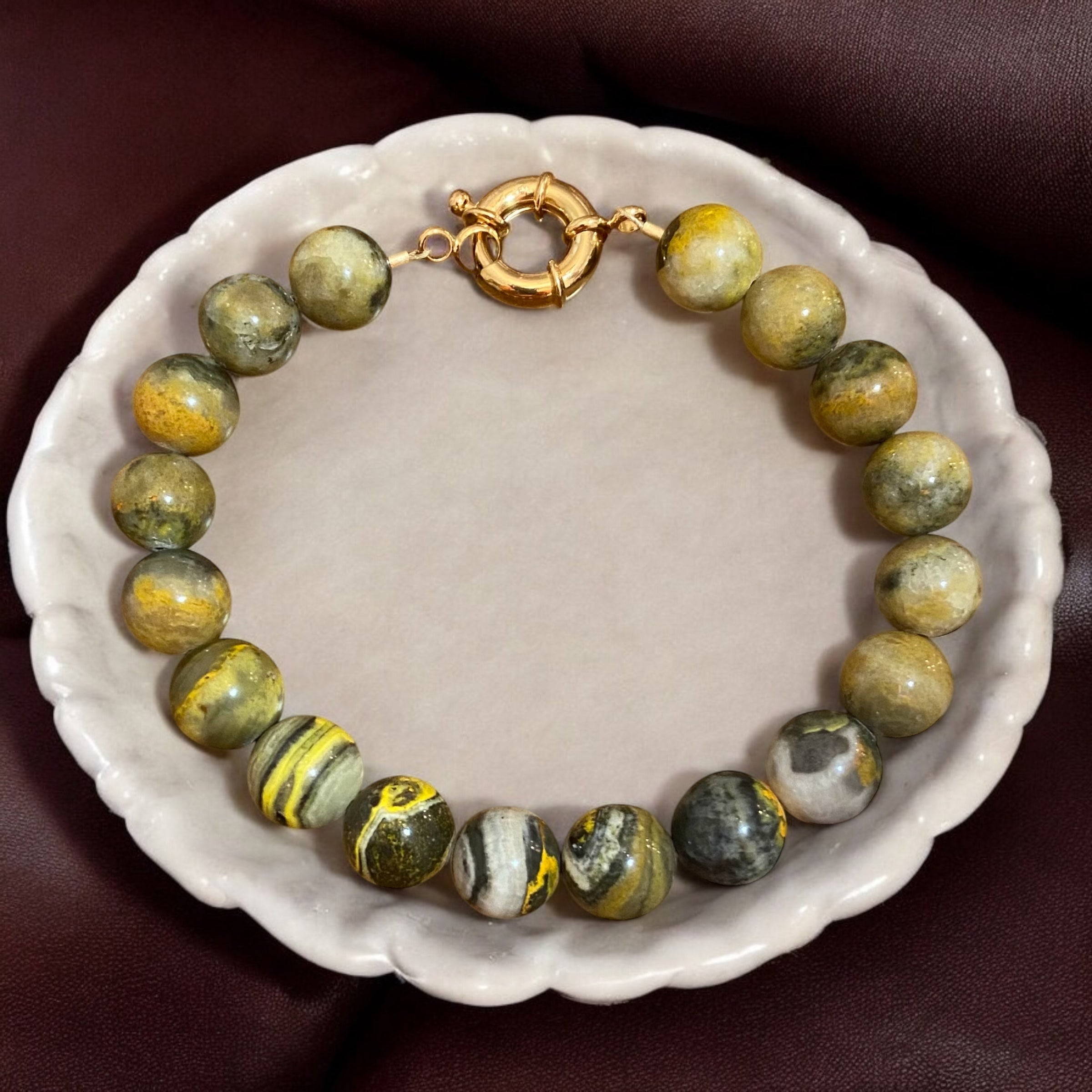 Men's bumblebee jasper bracelet displayed in a dish.