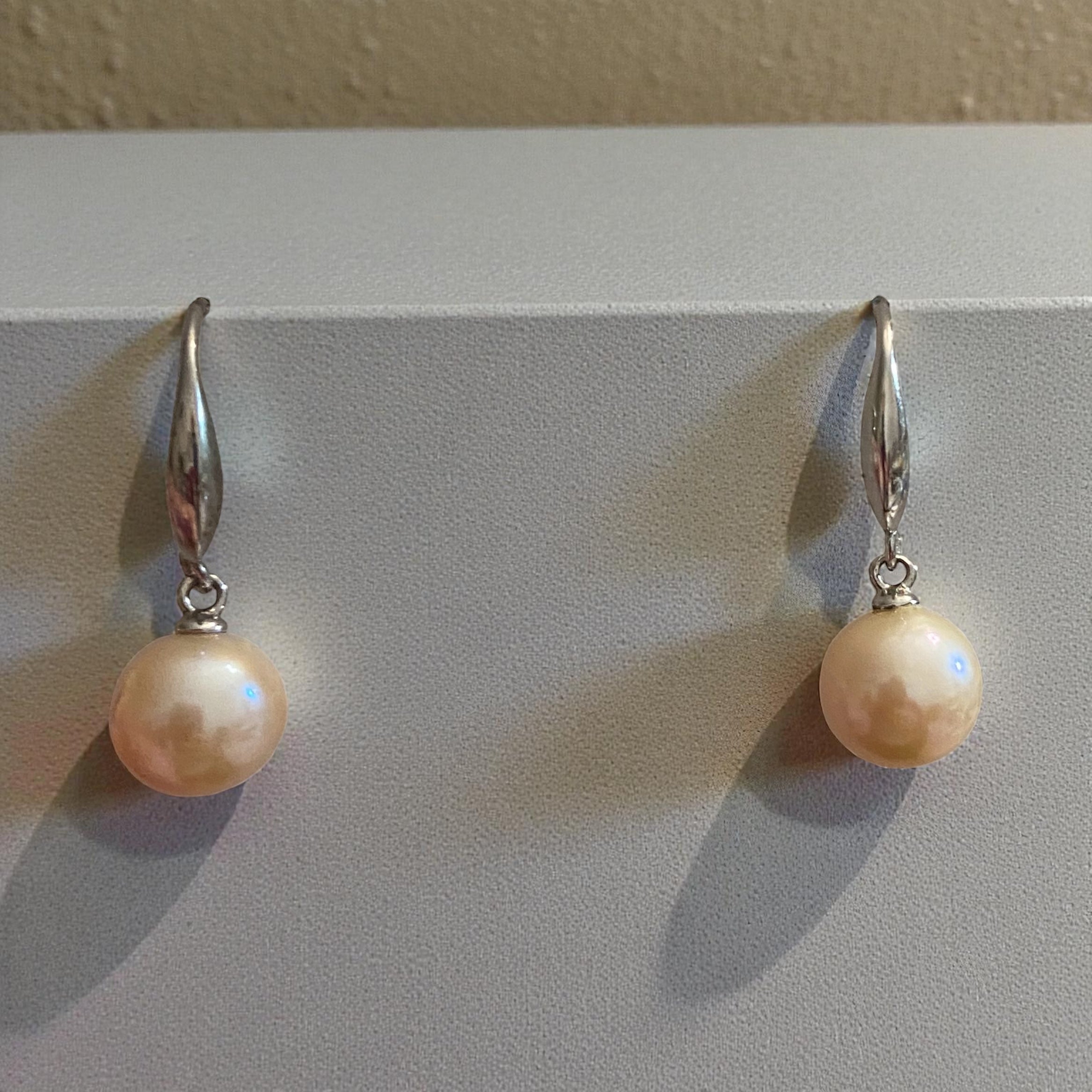 Pair of pearl earrings on a light gray background
